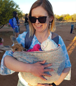 NIAA staff member Zoe Mansfield carrying a kangaroo joey