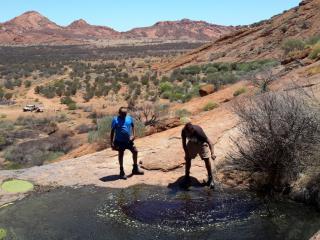Rangers monitoring a rock hole in Evarard Ranges. Photo: © APY