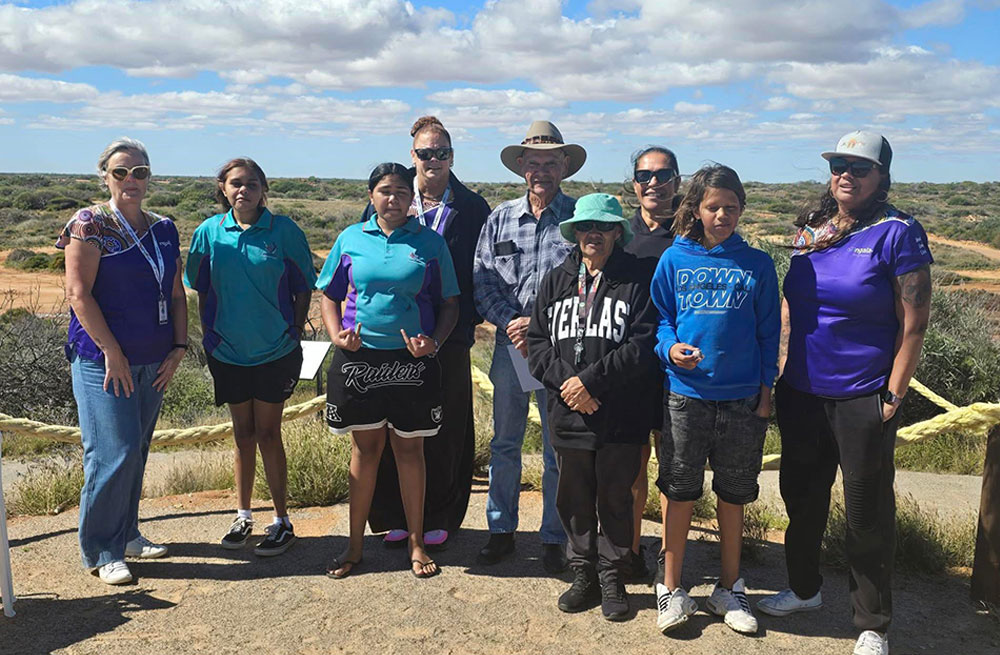 Participants of the Bush Classrooms posing for the camera with the bush scenery stretching out to the horizon