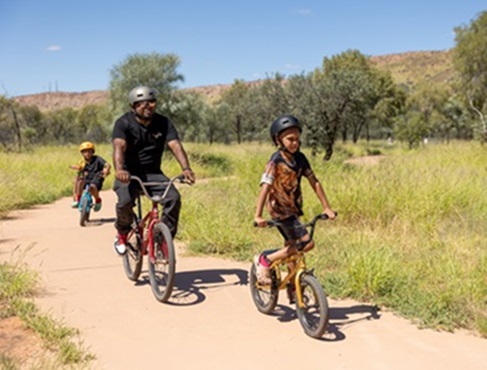 Two children and a man participate in the Larapinta Tracks school holiday program in Alice Springs, Northern Territory.