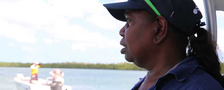An Indigenous ranger, Theresa Lemon, on a boat overlooking water undertaking NT Fisheries training