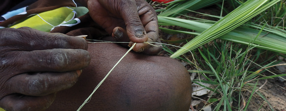 Evonne Munyungu from Bula’bula Arts in Ramingining NT, makes string from sand palm. Photo Kate Riley. 