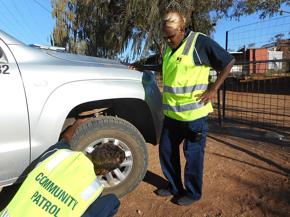 In this photograph community night patrollers Verna Peters and her colleague Albie (Mingkili) Wilson check their vehicle before the start of a night patrol shift.
