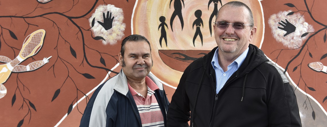 Members of the Murdi Paaki Regional Assembly in front of an Indigenous mural
