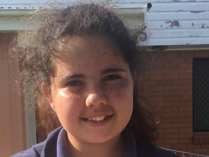 Indigenous girl, Alkira Blair-Bain, holding her Aboriginal Student of the Year award