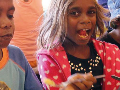 Indigenous children sitting at a table eating