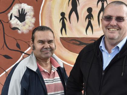 Former Murdi Paaki Regional Assembly member with community leader from Wentworth, standing in front of an Indigenous mural