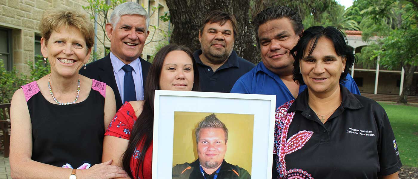 Jamiee Bartlett, holds a photograph of her husband Jason Bartlett, left to right, with Dr Sandra Thompson, from the WA Centre for Rural Health, Minister for Indigenous Health, and Aged Care Ken Wyatt AM, and Adrian Bartlett, Phil Bartlett and WACRH's Lenny Papertalk.