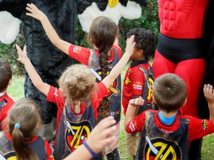 The photo shows Deadly Dan the Smoke Free Man delivering the anti-smoking message “You smoke, you choke” and children listening to Dan. Deadly Dan also has a book titled Deadly Dan at the League.