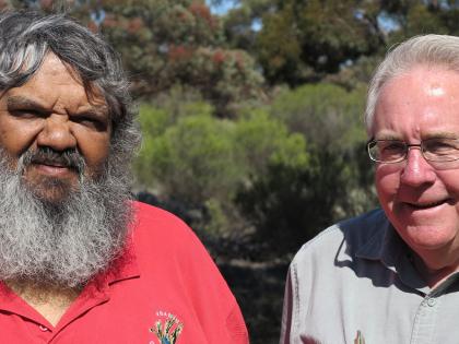 In this photo Les Shultz, Ngadju Conservation Aboriginal Corporation Chairman, and Peter Price, a Program Manager, are in the foreground of a bush scene. 