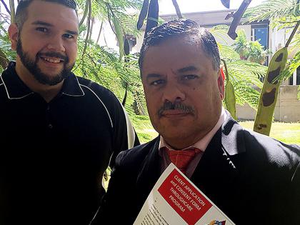 Prisoner Throughcare officers Sterling Wedel, left, and Trevor Prior are pictured in front a Poinciana tree. The Aboriginal and Torres Strait Islander Legal Service’s Throughcare program delivers intensive high-quality case management services focused targeted prisoners considered to be of a high risk of re-offending. Support is provided both before and after the prisoners are released from jail.