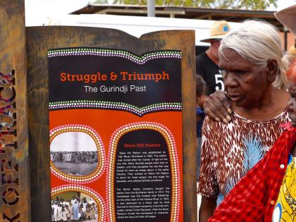 In this photo Gurindji Elders unveil a sign that marks the Wave Hill Walk-Off Walking Track at the Karungkarni Art and Culture Aboriginal Corporation. 