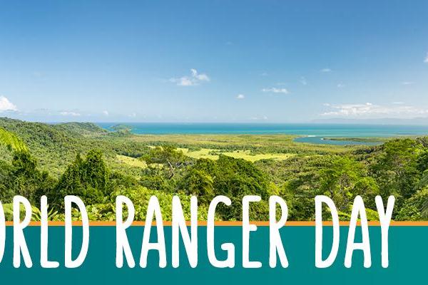At right is image of rainforest in foreground and sea and sky in the background. At left are the words: World Ranger Day.