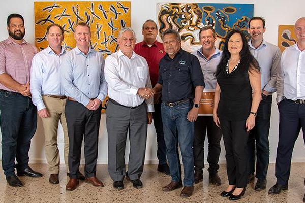 Minister Wyatt and Minister Canavan with the Indigenous Reference Group. There are nine men and one woman pictured, all wearing smart casual clothing, standing in front of colourful Indigenous artwork