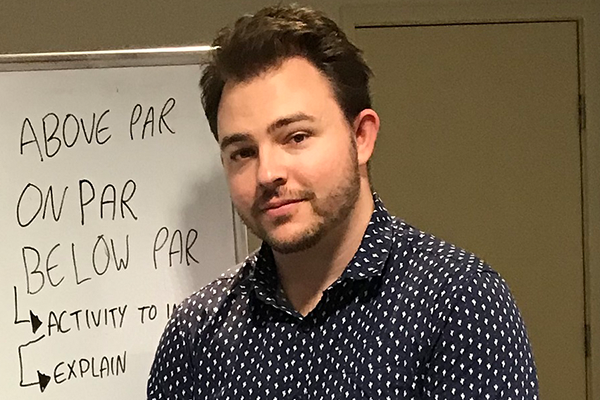 Image of Dylan Kimlin standing in front of a whiteboard