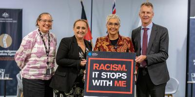 NIAA Group Manager Julie-Ann Guivarra standing alongside Deputy CEO Letitia Hope, CEO Jody Broun and Deputy CEO Blair Exell holding a black sign board with the words ‘Racism. It Stops With Me’