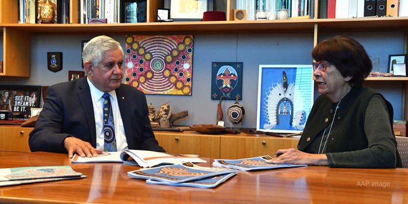 Joint Council on Closing the Gap Co-chairs Minister for Indigenous Australians, the Hon Ken Wyatt AM, MP and Pat Turner AM sitting at a meeting table with papers on the table. In the background is a bookshelf with Indigenous artwork and books. 