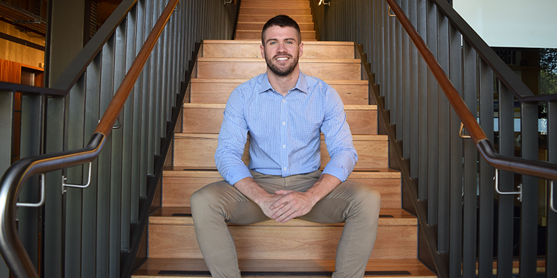 Image of Peter Honeyman smiling, sitting on a staircase